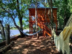 a tree house with a hammock in the woods at Chalet del lago Don Asterio in Ciudad del Este