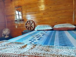 a bed in a room with a wooden wall at Chalet del lago Don Asterio in Ciudad del Este