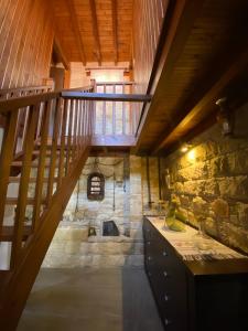 eine Treppe in einem Raum mit einer Steinwand in der Unterkunft Lofitiko in Lofou