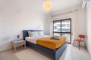 una camera da letto con un letto, una finestra e una sedia di Encanto by The Historic Center Lagos a Lagos