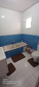 a bathroom with a tub and a toilet and a sink at Beautiful Apartment in Kantaoui Sousse tourist area in Hammam Sousse +29 photos