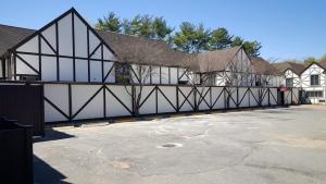 a building with a parking lot in front of it at East Norwich Inn in East Norwich