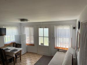 sala de estar con mesa, sofá y ventanas en Casuta -Maria-Kisház, en Sovata