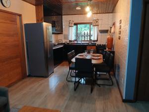 una cucina con tavolo, sedie e frigorifero di Casa Visconde 2 a Visconde De Maua