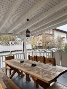 una mesa de madera y sillas bajo una pérgola blanca en De Luxe Villa, en Skopje