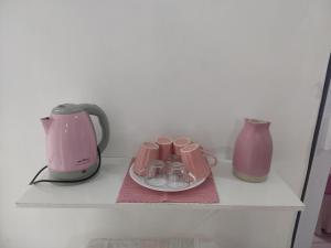 eine Kaffeemaschine und zwei Vasen auf einem Regal in der Unterkunft aconchegante casa - lagoinha in Nova Iguaçu