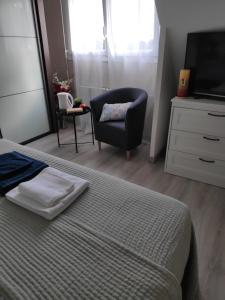 a bedroom with a bed and a chair and a television at Kastell-Mor 2 chambre d'hôtes à Santec in Santec