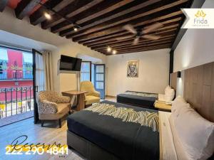 a bedroom with a bed and a couch and a table at Hotel Frida in Puebla +71 photos