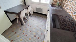 a kitchen with a counter and a table and chairs at Le Haras Ouest in Libourne +10 photos