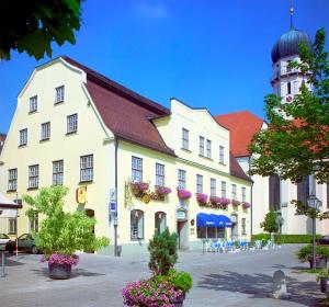 un grande edificio bianco con torre dell'orologio di Hotel Alte Post a Schongau