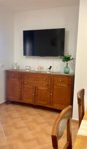 a large wooden dresser with a television on top of it at Casa Abuela Cati in Sanlúcar de Guadiana