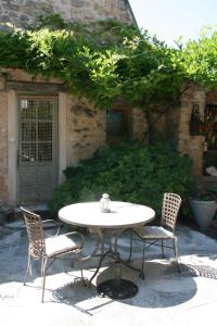 a white table and two chairs and a table and chairs at Le Jas des Nevières in Pierrerue