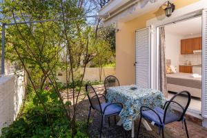 a patio with a table and chairs and a bedroom at Dimitris Studios in Karavomylos