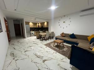 a living room with a couch and a table at Kelibia luxury 2 bed flat in Ḩammām al Ghazzāz