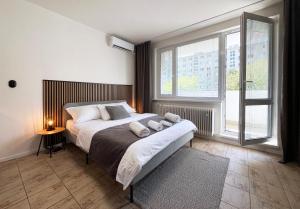 a bedroom with a bed and a large window at New cozy studio, AC & Balcony in Bratislava