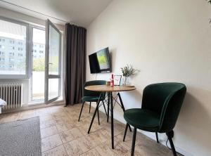 a room with a table and chairs and a window at New cozy studio, AC & Balcony in Bratislava