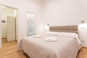 a bedroom with a large bed with two towels on it at AM6 - Dimora del Borgo in Perugia