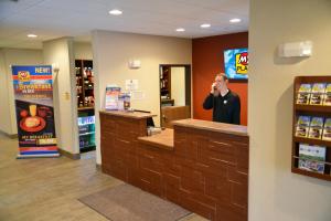 a man talking on a cell phone at a counter in a store at My Place Hotel-Bend, OR in Bend