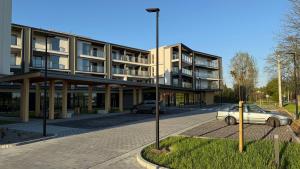 a building with two cars parked in front of it at Nowa Dzielnica Cztery Apartamenty przy Tężni in Busko-Zdrój