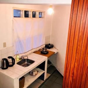 eine kleine Küche mit Spüle und Fenster in der Unterkunft Hermosa Habitación en Samaipata in Santa Cruz de la Sierra