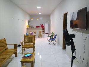 a living room with chairs and a flat screen tv at La Fortaleza Marapanim in Marapanim