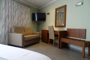 a hotel room with a desk and a chair and a mirror at Nou Avenida in Gata de Gorgos
