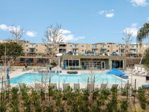 een groot zwembad voor een gebouw bij Sunlit Marina View 2BR - Blue Agate Seaside Gem in Los Angeles +32 foto's