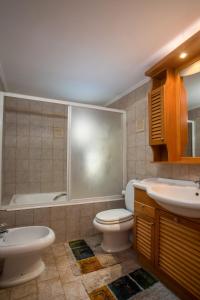 a bathroom with a toilet and a sink and a tub at Socrates traditional house in Haraki +34 photos
