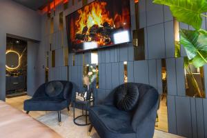 a lobby with two chairs and a fireplace at L'élégance - Suite Romantique - Jacuzzi Privatif in Sarrebourg