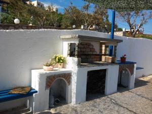 a small house with a fireplace in front of a wall at Sarris Planet in Ermoupoli