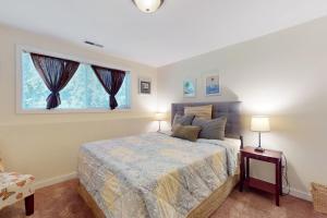 a bedroom with a bed with two lamps and a window at Casa Esmeralda in Lakewood