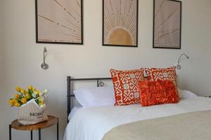 a bedroom with a bed with orange pillows and a table at Residenza Lucano - Appartamento Red in Monserrato