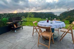 a table with wine glasses and a grill on a patio at A Casa da Moucha in Muxia