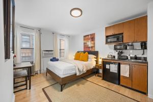 Un dormitorio con una cama grande y una cocina. en Times Square Studio near Restaurants & Shopping, en Nueva York
