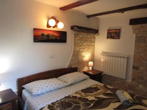 a bedroom with a bed in a room with a brick wall at Villa Sartori in Sarići +55 photos