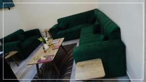 a living room with a green couch and a table at النخيل للشقق الفندقية ALnakheel hotel apartment in Aqaba