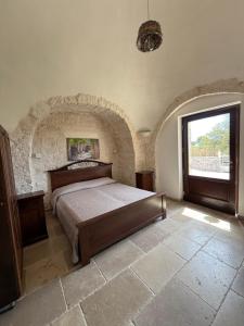 a bedroom with a bed in a room with a window at B&B Masseria Nardelli in Locorotondo