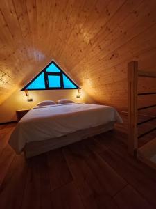 a bedroom with a bed in a wooden ceiling at La Livada Chalet in Vişeu de Sus +47 photos