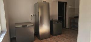 a refrigerator and a trash can in a room at Barry Farmstay in Zuurbraak