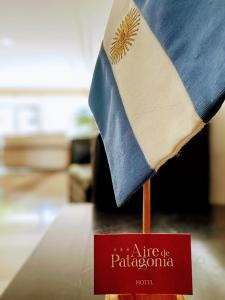 a flag on top of a table with a red sign at Hotel Aire de Patagonia in Río Gallegos