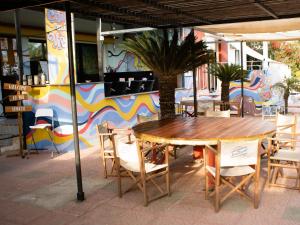 una mesa de madera y sillas frente a un edificio en House of Nissus Hostel, en Ayia Napa