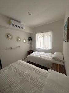 zwei Betten in einem Zimmer mit Fenster in der Unterkunft Casa Khira in Playa del Carmen + 20 Fotos