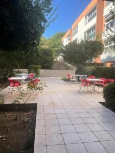 a patio with red chairs and tables and a building at Résidence Balcon Du Canigou - Joli studio dans la résidence Les Balcons du Canigou MAE-5381 in Vernet-les-Bains