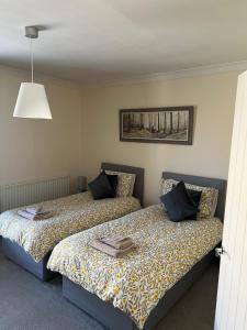 een slaapkamer met twee bedden en een lamp bij Epworth Cottage in Crich