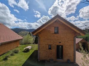 a wooden cabin with a picnic table in front of it at la brume des cimes in Bussang