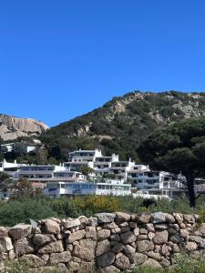 a large white building in front of a mountain at TheView108, Rena Bianca in Baja Sardinia