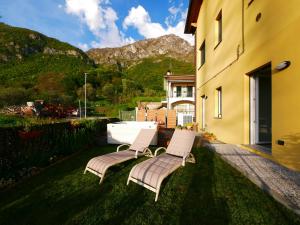 two chairs sitting on the grass next to a building at Restorative stay Garden Jacuzzi Lake View in Lierna