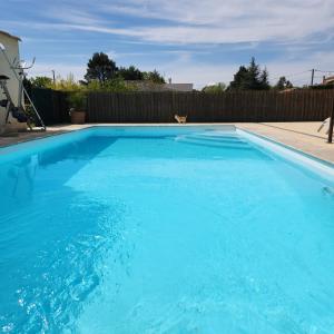 a large blue swimming pool in a yard at Loft Q-PIDON in Saint-Laurent-la-Vernède