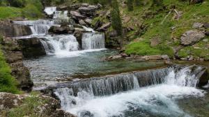 eine Gruppe von Wasserfällen in einem Gebirgsbach in der Unterkunft Hotel Ballarin in Torla-Ordesa