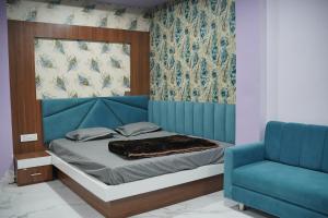 ウッジャインにあるHotel Shree Radhe Krishnaのベッドルーム1室(ベッド1台、青い椅子付)